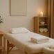 A serene and calming massage room featuring a massage table, candles, and soft towels.
